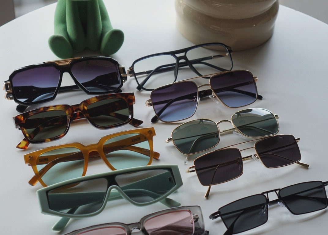 Collection of sunglasses on a white surface