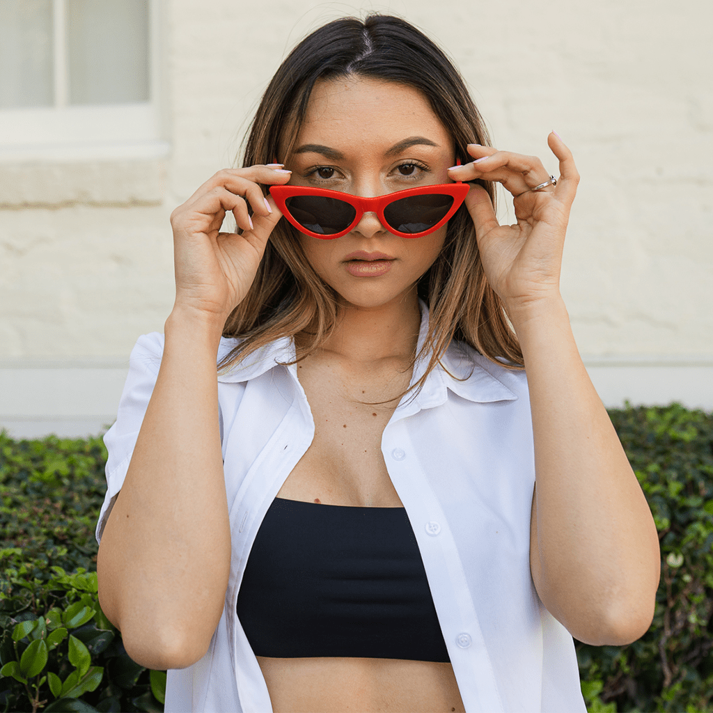 Woman wearing red cat eye sunglasses.