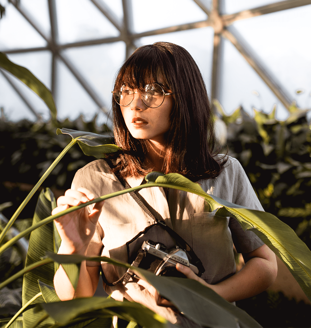 Woman holding a plant in an indoor setting with geometric ceiling design