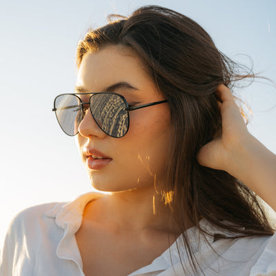 Woman wearing sunglasses with a clear blue sky background